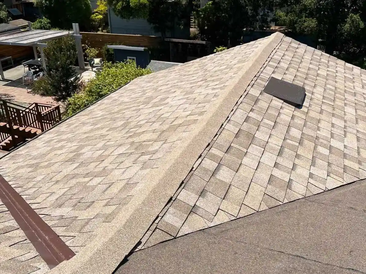 Aerial view of a newly completed residential roof replacement with clean shingle lines