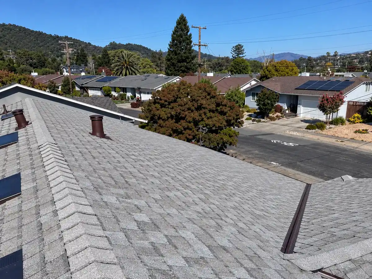 Rooftop view along the ridge of an asphalt shingle roof with vents, the kind of view a roofer documents during an inspection.