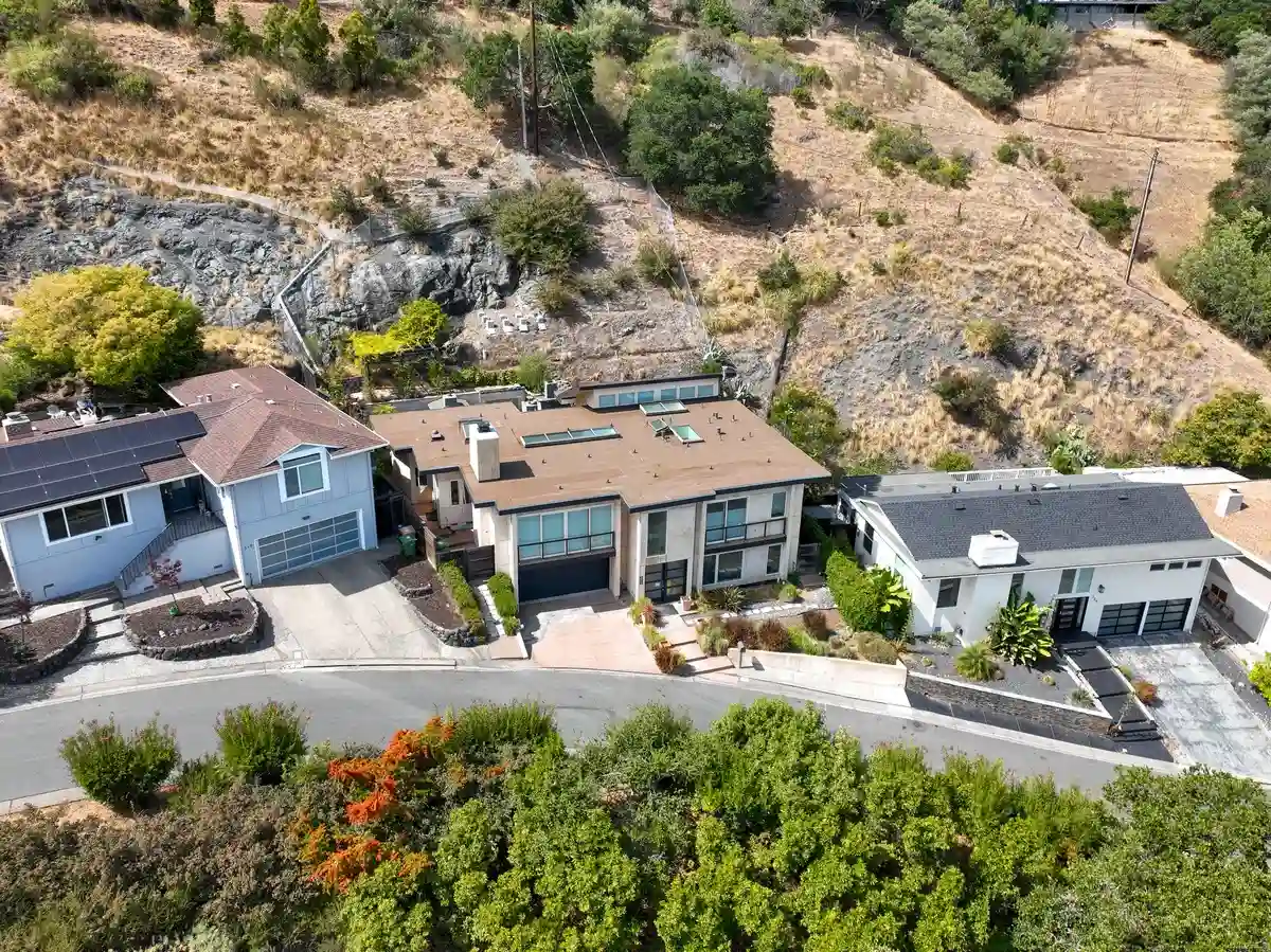 Hillside home with a low-slope roof, multiple skylights, and a raised roof section with windows